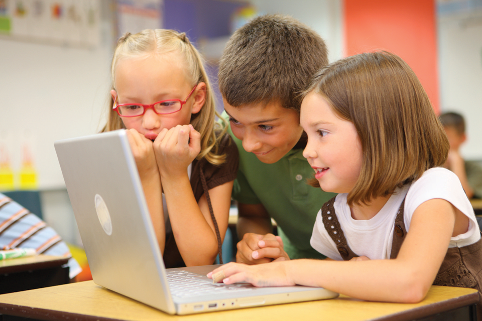 Three kids playing on computer